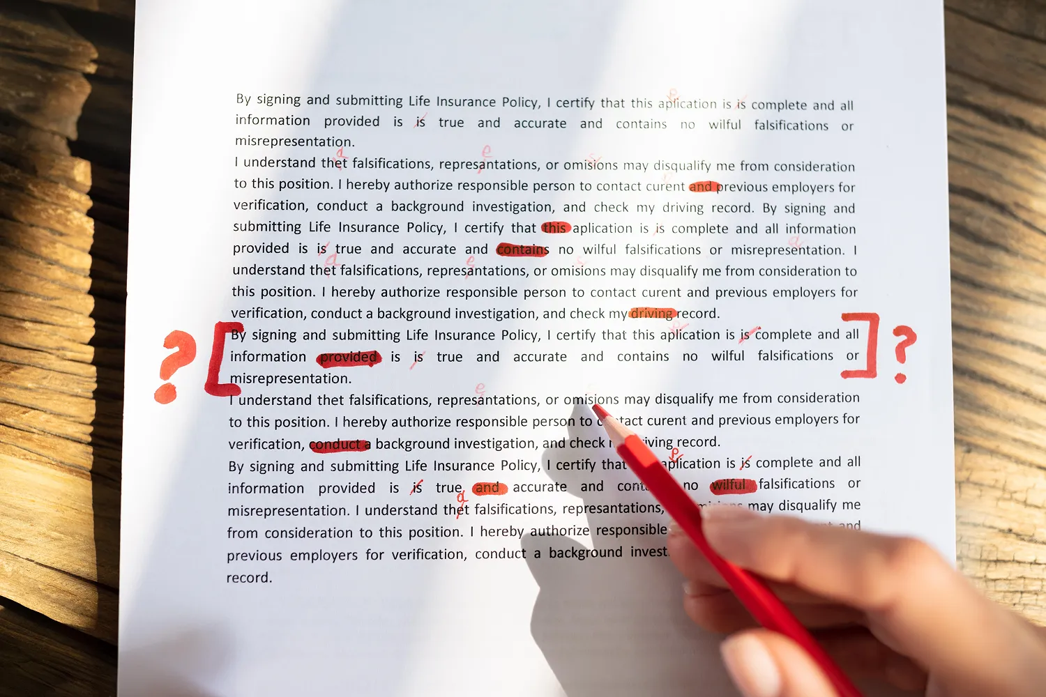 Человек отмечает ошибку в тексте красным маркером во время проверки информации